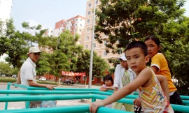 Trẻ em ở khu chung cư bán đảo Linh Đàm ra mấy cột sắt để chơi. ảnh: Hồng Vĩnh