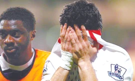 Luis Suarez cố giấu những giọt nước mắt thất vọng vào trong vạt áo. Ảnh: Getty Images 