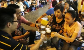 Người dân uống bia ngoài vỉa hè trên phố Tạ Hiện - Hà Nội. Ảnh: Như Ý