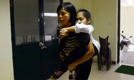 Bố mẹ cõng con gái xương thủy tinh vào tận phòng thi