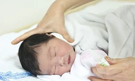 Dùng nước muối sinh lý để vệ sinh mũi cho trẻ.