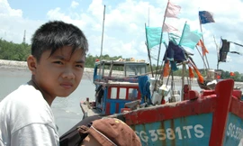 Cảng cá đìu hiu. Bé Đỗ 13 tuổi không biết chữ đang đợi bố đánh cá trở về. Ảnh: T.N.A 