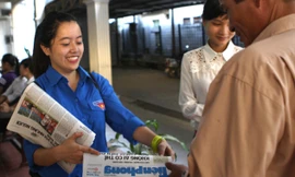 Sinh viên tình nguyện phát báo Tiền Phong cho phụ huynh. Ảnh: Mai Xuân Tùng