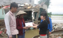 Đại diện báo Tiền Phong trao quà cứu trợ khẩn đến nhà bị sập hoàn toàn và có người mất do lũ