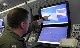 Một quân nhân Mỹ trên máy bay giám sát P-8A Poseidon xem màn hình máy tính cho thấy hoạt động xây dựng của Trung Quốc trên Đá Chữ Thập thuộc quần đảo Trường Sa của Việt Nam. Trung Quốc đã chiếm đóng và cải tạo trái phép thực thể này.