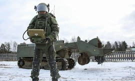 Một binh sỹ Nga mang bộ giáp hỗ trợ để điều khiển robot phá mìn Uran-6