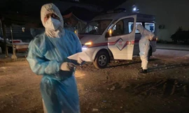 Các quan chức y tế và một xe cấp cứu chờ đợi để thu thập các bệnh nhân COVID-19. (Rasmei News)