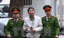 Cảnh sát dẫn giải bị cáo Trịnh Xuân Thanh, nguyên Chủ tịch Hội đồng quản trị, Tổng giám đốc Tổng Công ty Cổ phần Xây lắp dầu khí Việt Nam - PVC đến tòa. (Ảnh: Doãn Tấn/TTXVN)