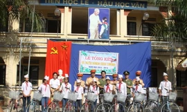 Đại diện đoàn thanh niên của Công an Hà Nội tặng xe đạp cho các em học sinh nghèo vượt khó