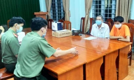 P.T (áo cam) tại cơ quan công an. Ảnh: CACC