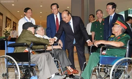 Thủ tướng thăm hỏi các đồng chí thương binh nặng tới dự buổi gặp mặt. Ảnh: VGP/Quang Hiếu
