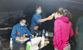 Các tình nguyện viên đo thân nhiệt, hỗ trợ người dân khai báo y tế ở xã Tam Hiệp, huyện Phúc Thọ, Hà Nội