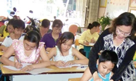 Cô Uyên đang hướng dẫn cho học viên tập viết chữ đẹp. Ảnh: H.Phương (Thanh Niên)