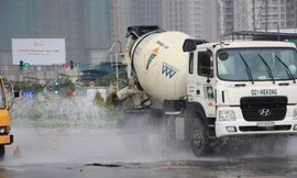 Xe cộ lưu thông qua khu vực nước máy tràn ra mặt đường đã làm nước bắn lên tung tóe