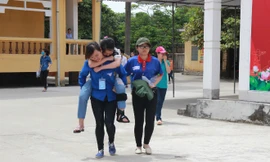 Thí sinh Ngô Thị Quỳnh Huyền được sinh viên tình nguyện cõng ra khỏi phòng thi