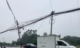 Vì sao hàng cột điện nghiêng ngả giữa QL 1 qua Hà Nội chưa thể di chuyển? 