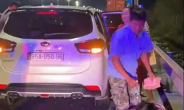 Dừng xe trên cao tốc, ngồi bệt dưới đường bày biện đồ ăn để ăn tối