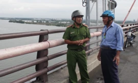 Đại uý Nguyễn Minh Nhựt nói chuyện với bảo vệ cầu Cần Thơ về việc giữ gìn an ninh trật tự trên cầu.