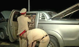 Lực lượng CSGT kiểm tra số gỗ trắc lậu trên xe ôtô bán tải hiệu Toyota Hilux 29C - 01268 do Trần Văn Tuyến điều khiển. Ảnh: CA.