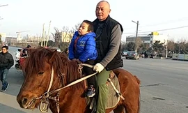 Ông bố cưỡi ngựa đón con tan học mẫu giáo ở Trung Quốc