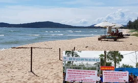 Hàng chục người dân bức xúc căng băng rôn, phản đối doanh nghiệp lập hàng rào chặn đường xuống biển Ông Lang. Ảnh: Việt Tường. 