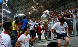 Khán giả sợ hãi bỏ chạy khi những cổ động viên quá khích của hai đội lao vào nhau. 