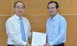 Đồng chí Nguyễn Thiện Nhân, Ủy viên Bộ Chính trị, Bí thư Thành ủy TPHCM, trao quyết định điều động, bổ nhiệm cho đồng chí Lê Văn Minh. Ảnh: VIỆT DŨNG.