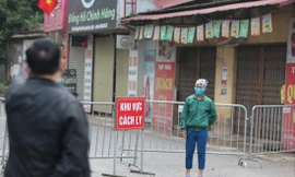 Một người dân được nhắc nhở khi đi qua khu vực cách ly thôn Hạ Lôi Ảnh: Hoàng Mạnh Thắng