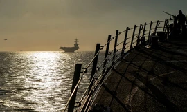 Quân nhân Mỹ trên tàu khu trục USS Bainbridge, phía xa là tàu sân bay USS Abraham Lincoln trên eo biển Gibralta ngày 13/4 ảnh: Reuters/Sputnik