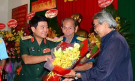 Thượng tướng Võ Văn Tuấn tặng hoa chúc mừng Anh hùng Nguyễn Văn Bảy và nhà văn Trúc Phương tại lễ ra mắt tập sách “Người Anh hùng chân đất”, tháng 4/2019