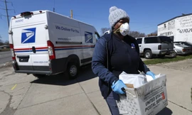 Một nhân viên USPS giao hàng với găng tay và khẩu trang ở Warren, bang Michigan