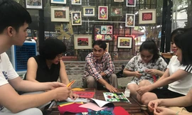 Anh Lê Việt Cường (áo sọc) và họa sĩ Đặng Thị Khuê (áo đen) hướng dẫn các bạn trẻ khuyết tật làm tranh ảnh Nhã Khanh