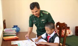 Trung tá Zơ Râm Thức, Chính trị viên Đồn Biên phòng cửa khẩu Nam Giang dạy học cho con nuôi Zơ Râm Dũng