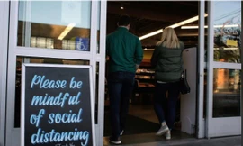 Tấm biển mới dựng trước cửa hàng ở Seattle, bang Washington có dòng chữ: Chú ý giữ khoảng cách ảnh: REUTERS