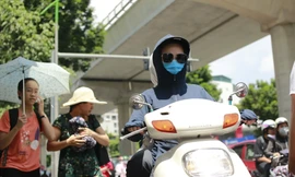 Người dân chống nắng bằng trang phục kín khi đi trên đường Xuân Thủy, Cầu Giấy, Hà Nội chiều 15/7 Ảnh: như ý