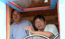 Ông Lê Viết Chữ (bên phải) đang cầm lái chiếc tàu Hoàng Sa ảnh: Văn Chương 
