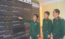 Thượng úy Trần Văn Vượng hướng dẫn đồng đội trên bảng tín hiệu nhận dạng tàu thuyền trên biển ẢNH: N.S