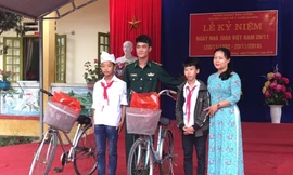 Chỉ huy Tiểu đoàn Huấn luyện - Cơ động Bộ đội Biên phòng Lào Cai tặng xe đạp cho hai em Thắng và Vảng