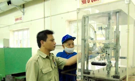 Kỹ sư Nguyễn Tiến Hưng (trái) kiểm tra thiết bị sản xuất sản phẩm quốc phòng tại Nhà máy Z121