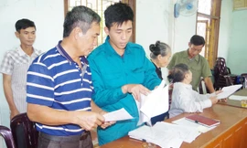 Cán bộ Ban CHQS xã Đồng Văn, huyện Thanh Chương, Nghệ An hướng dẫn người dân làm hồ sơ tham gia dân công hỏa tuyến theo Quyết định 49