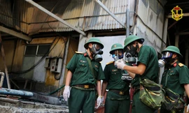 Cán bộ Viện Hóa học Môi trường Quân sự lấy mẫu vật tại hiện trường vụ cháy. Ảnh: BCHH