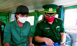 Cán bộ Đồn Biên phòng Cần Thạnh (TPHCM) hướng dẫn người dân các biện pháp phòng chống dịch COVID-19