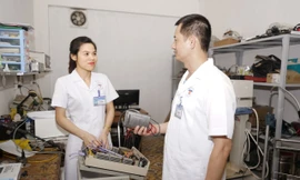 Đại úy Bùi Thị Hoa (bên trái) trao đổi công việc cùng đồng nghiệp 
