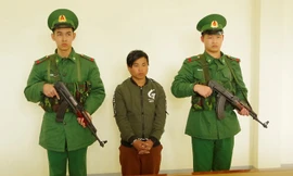 Sùng Seo Tráng (giữa) nghe đọc lệnh bắt tại Đồn Biên phòng Cửa khẩu quốc tế Lào Cai