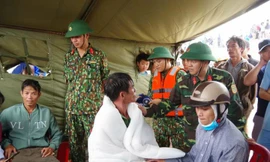 Lực lượng cứu hộ của Quân đội và người thân thăm hỏi tình hình sức khỏe các nạn nhân trên tàu Vietship 01 sau khi được cứu hộ vào bờ an toàn