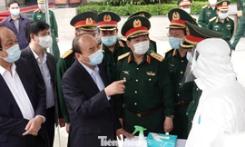 Thủ tướng Nguyễn Xuân Phúc trò chuyện với nhân viên xe xét nghiệm cơ động của Viện Y học dự phòng Quân đội, tại Cục Quân y, chiều 22/3. Ảnh: Nguyễn Minh