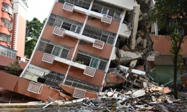 Tòa nhà bị bật móng và nghiêng hẳn sang một bên sau tiếng động lớn.