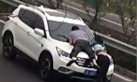 Cô gái và người yêu mới không ngại đu bám ca pô đòi tiền dù có thể nguy hiểm tới tính mạng. Ảnh cắt từ clip.