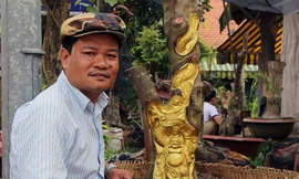 Anh Trần Quốc Việt bên tượng Phật Di Lặc được khắc tinh xảo trên cây khế còn sống