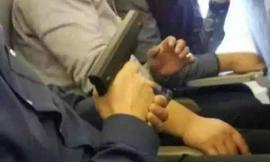 Bức ảnh người đàn ông cầm súng chĩa vào hành khách trên một máy bay ở sân bay quốc tế Bắc Kinh đăng trên mạng. (Ảnh: Sina)